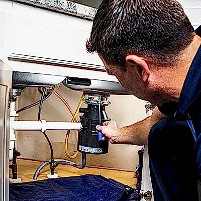 Z PLUMBERS service technician fixing garbage disposal