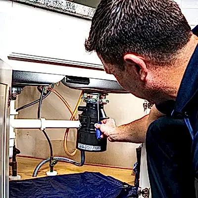 Z PLUMBERS service technician fixing garbage disposal