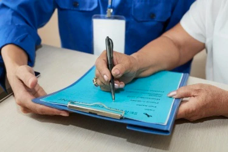Close-up of hand writing on clipboard