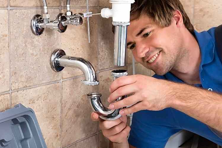 Technician placing part on pipes