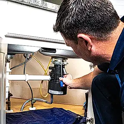 Z PLUMBERS service technician fixing garbage disposal