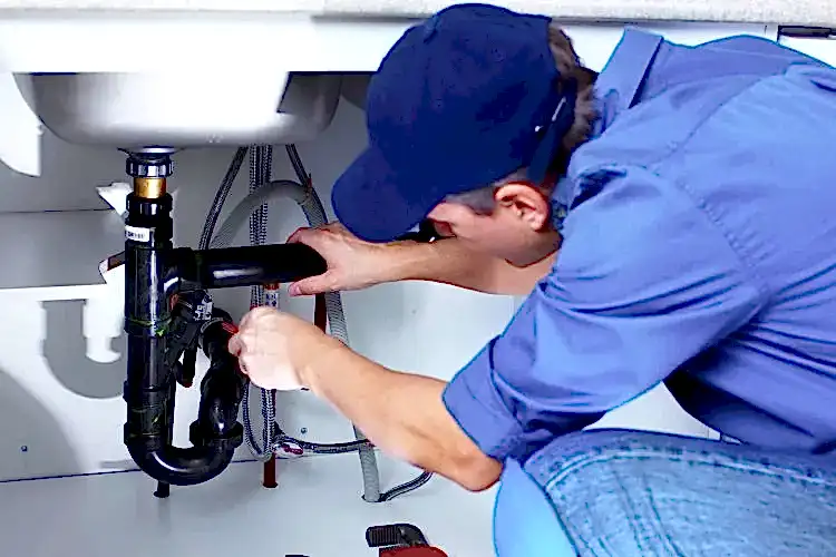 Technician working on kitchen sink