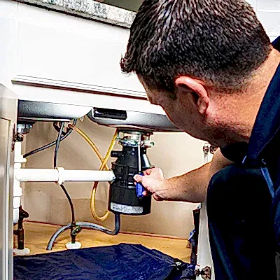 Z PLUMBERS service technician fixing garbage disposal
