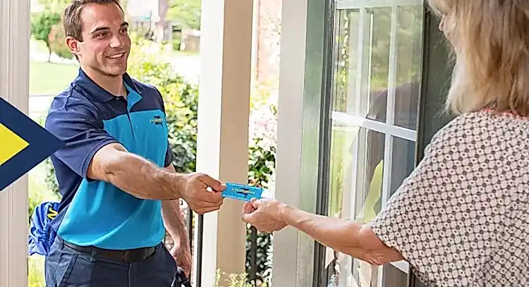Z Plumbers technician handing business card to female client