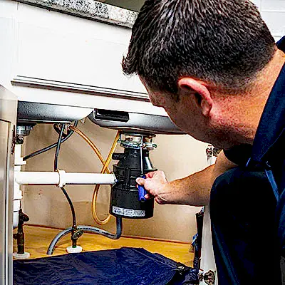 Z PLUMBERS service technician fixing garbage disposal