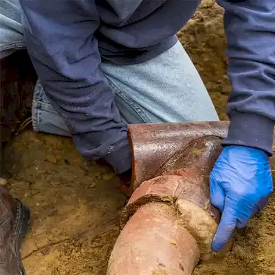 Worker inspecting sewer pipe
