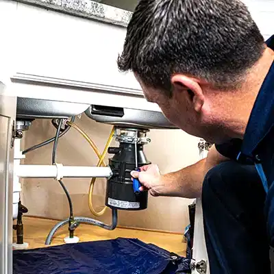 Z PLUMBERS service technician fixing garbage disposal