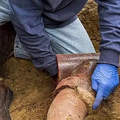 Worker inspecting sewer pipe