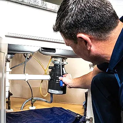 Z PLUMBERS service technician fixing garbage disposal