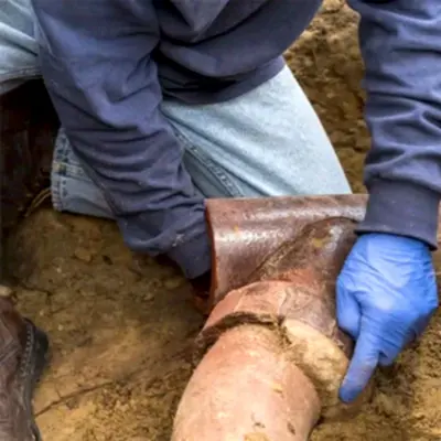 Worker inspecting sewer pipe