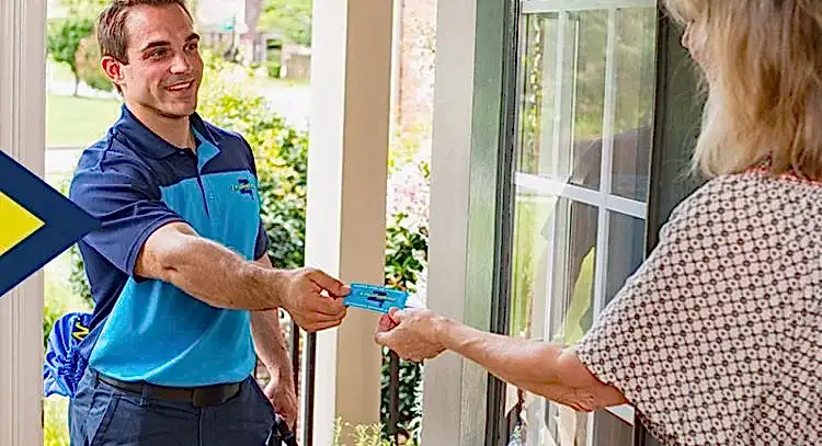Z Plumbers technician handing business card to female client