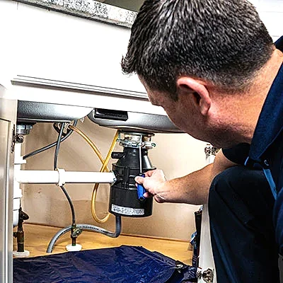 Z PLUMBERS service technician fixing garbage disposal
