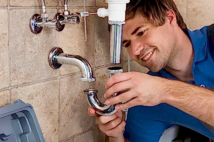 Technician placing part on pipes