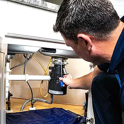Z PLUMBERS service technician fixing garbage disposal