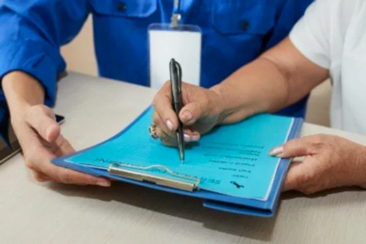 Close-up of hand writing on clipboard