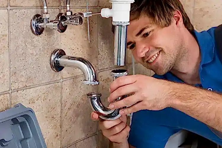Technician placing part on pipes