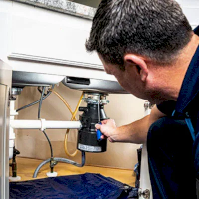 Z PLUMBERS service technician fixing garbage disposal
