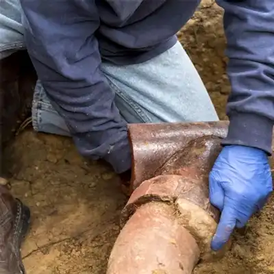 Worker inspecting sewer pipe
