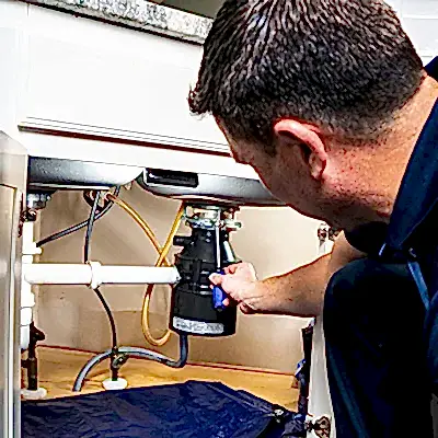 Z PLUMBERS service technician fixing garbage disposal