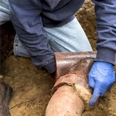 Worker inspecting sewer pipe