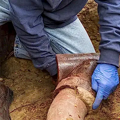 Worker inspecting sewer pipe