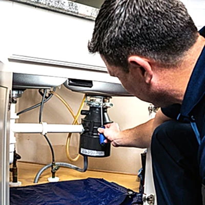 Z PLUMBERS service technician fixing garbage disposal