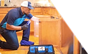 Z PLUMBERS worker kneeling and shining light under cabinet