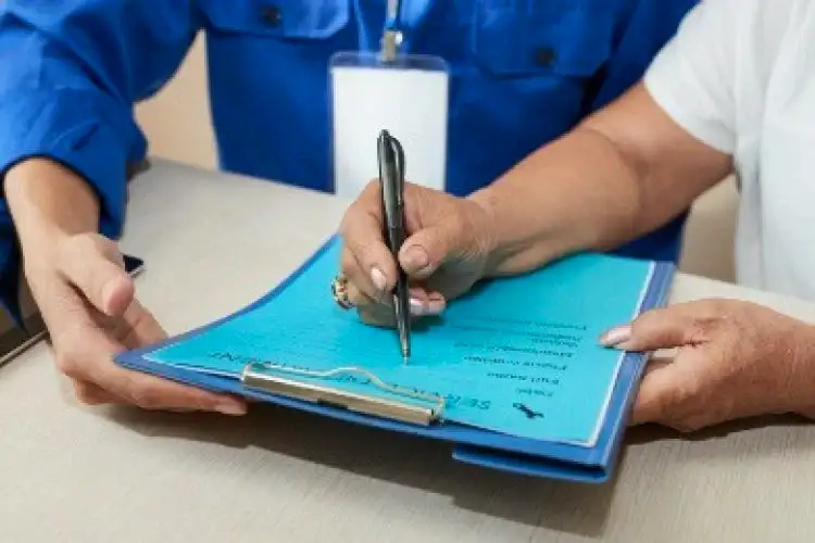 Close-up of hand writing on clipboard