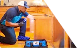 Z PLUMBERS worker kneeling and shining light under cabinet