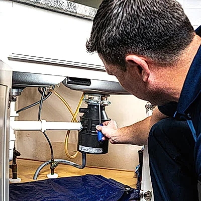 Z PLUMBERS service technician fixing garbage disposal