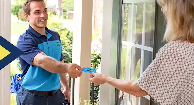 Z Plumbers technician handing business card to female client