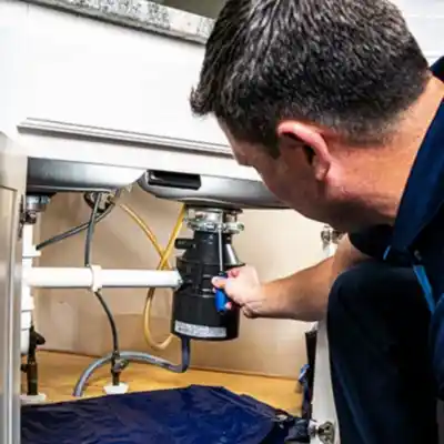 Z PLUMBERS service technician fixing garbage disposal