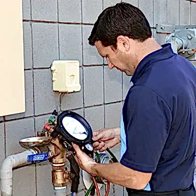 Technician checking sewer backflow gauge