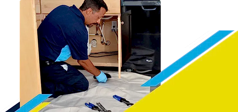 Z PLUMBERZ of Toledo technician inspecting pipes under kitchen sink