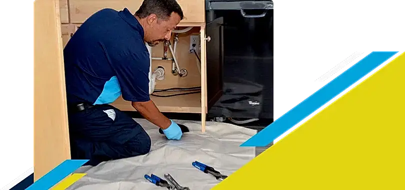 Z PLUMBERZ of North Dallas technician inspecting pipes under kitchen sink