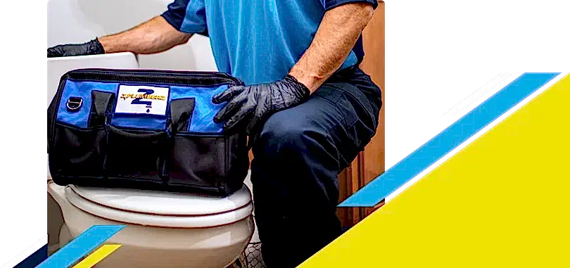 Z PLUMBERZ of North Dallas technician kneeling with tool bag on toilet