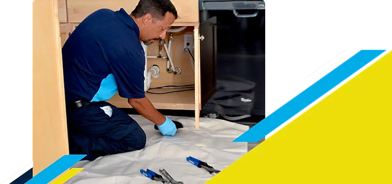 Z PLUMBERZ of Atlanta technician inspecting pipes under kitchen sink