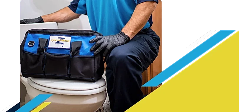 Z PLUMBERZ of Atlanta technician kneeling with tool bag on toilet